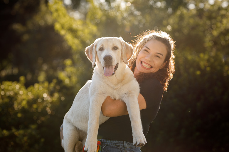 Young woman holding her dog up
