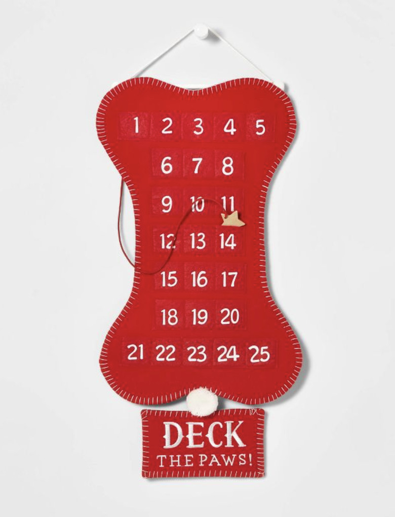 Red felt bone-shaped advent calendar for dogs with a sign underneath that reads Deck the Paws!