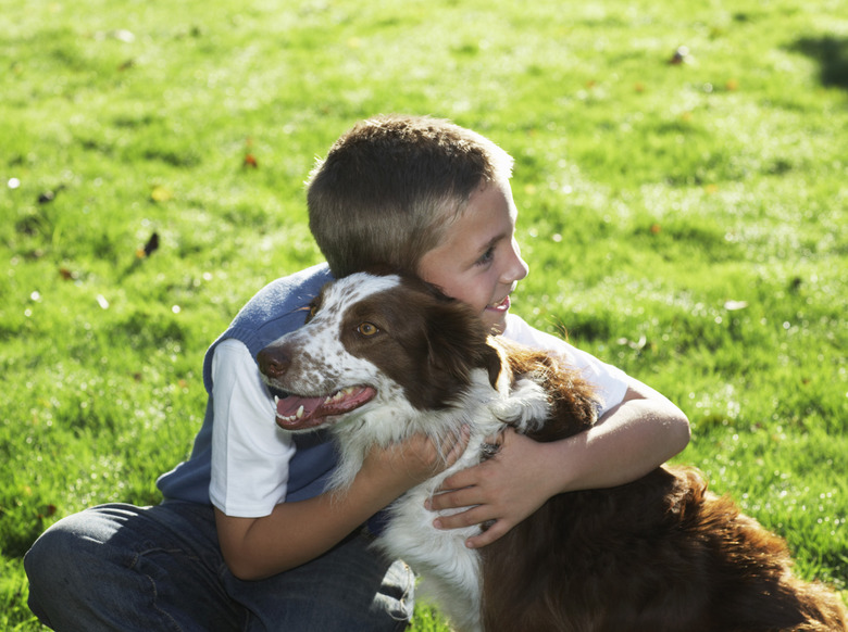 Boy 7-9 hugging dog