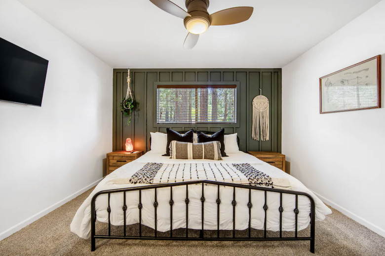 Primary bedroom of BearFoot Summit Haus with a dark green accent wall with decorative molding