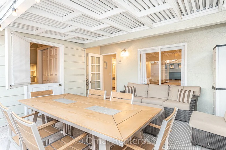 Second-story covered patio with outdoor seating and dining in Newport Beach.