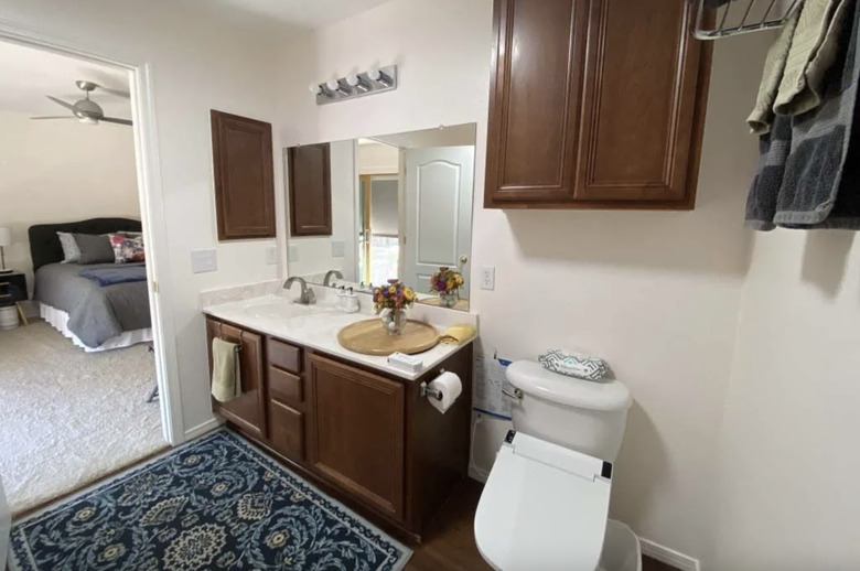 The bathroom of the private room with a walnut-colored vanity with a single sink