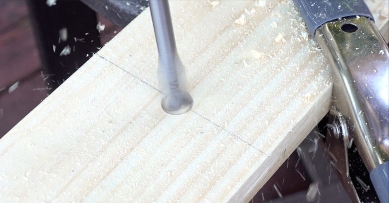 Drilling holes into planks for DIY dog puzzle feeder.