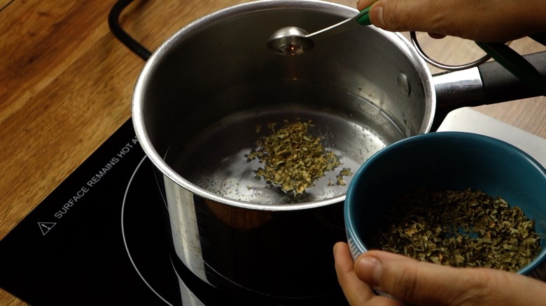Making catnip tea spray for DIY cat toys out of wine corks.