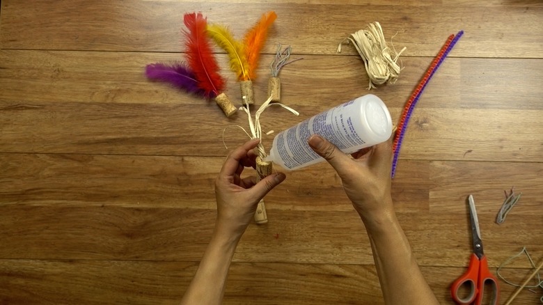 Gluing twine for DIY cat toys out of wine corks.