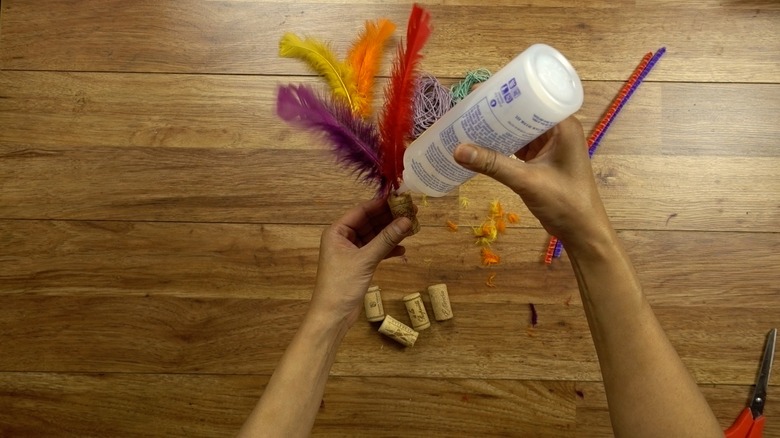 Gluing feathers to cork for DIY cat toys out of wine corks..