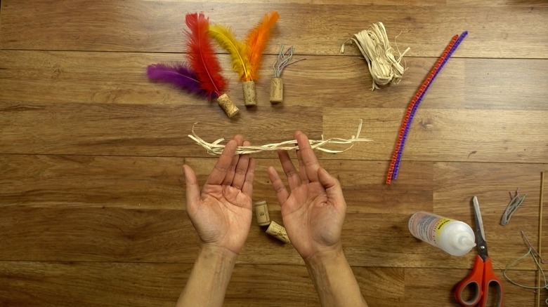 Cutting raffia for DIY cat toys out of wine corks.