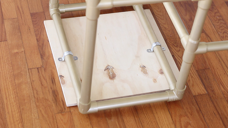 Securing board to pipes with pipe straps