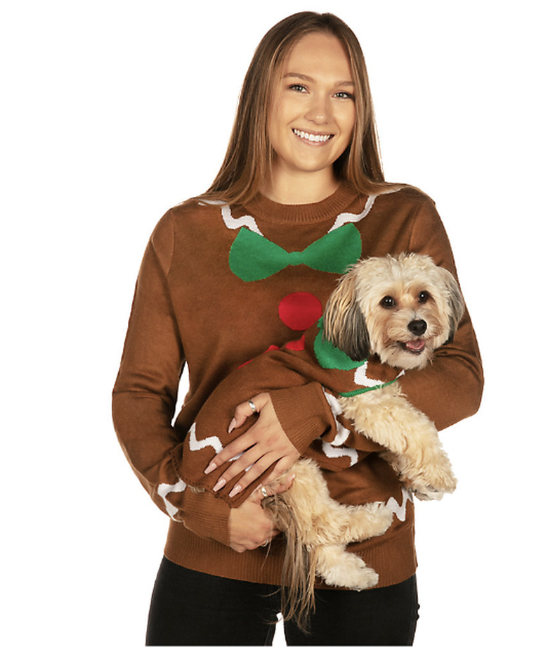 Woman and dog wearing matching gingerbread sweaters with icing