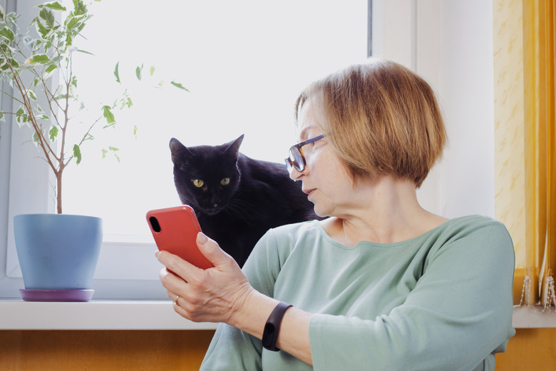 Senior blonde woman using mobile phone for video call with friend or children