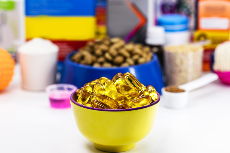 bowl with omega 3 capsules and pet food in the background