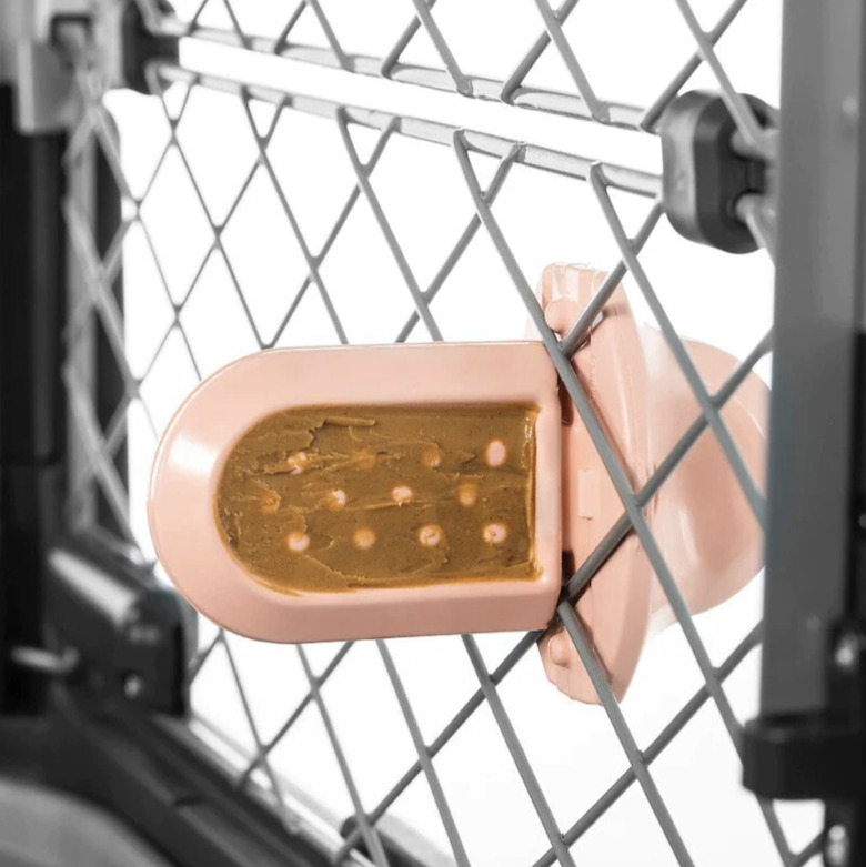Groov in pink attached the a wire kennel with peanut butter smeared on it. Both sides of the 'popsicle' end have little nubs that make it harder for your dog to lick everything off.