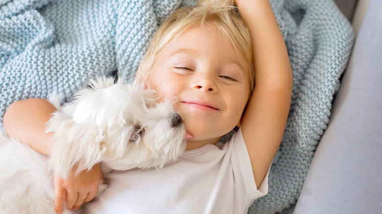 Puppy snuggling with a toddler