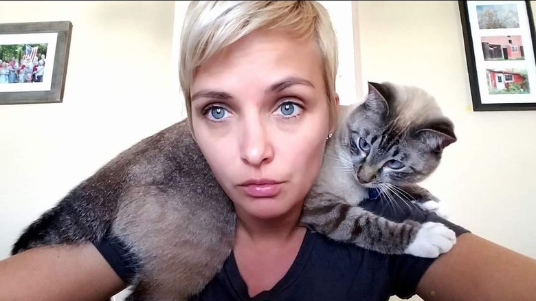 cat supervises woman on computeer