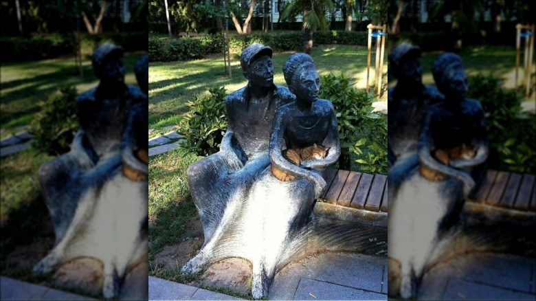Cat curled in lap of statue
