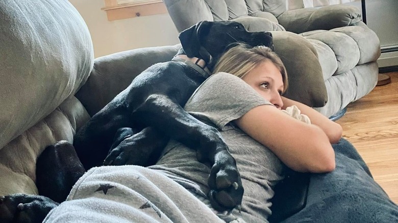 dog spoons woman on couch