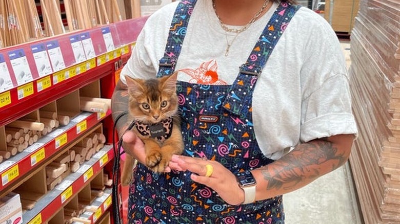 A woman takes her kitten with her to the hardware store.