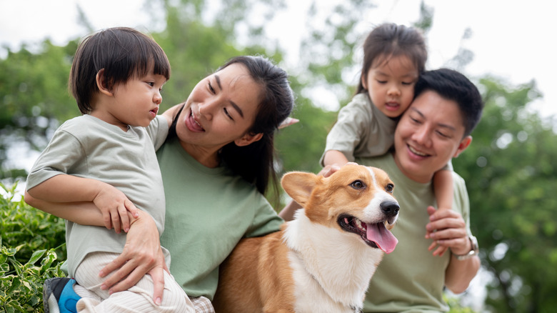 Family of four people with their happy-looking dog