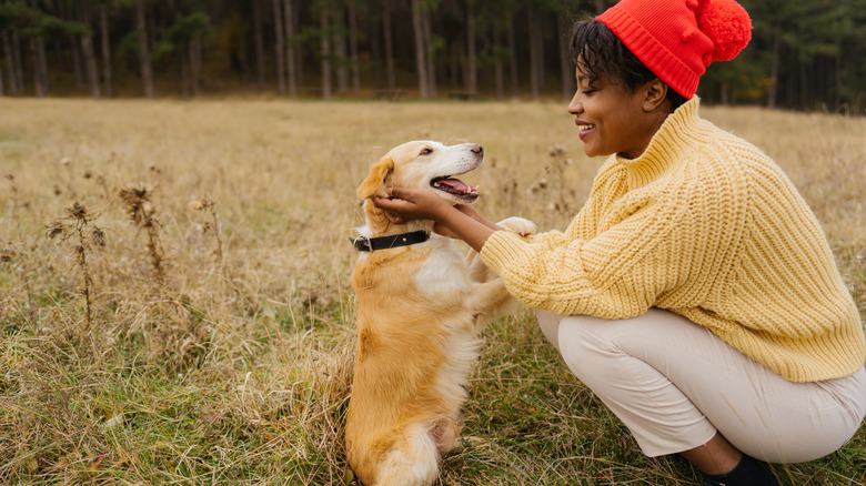 Woman holding her happy dog's face outside
