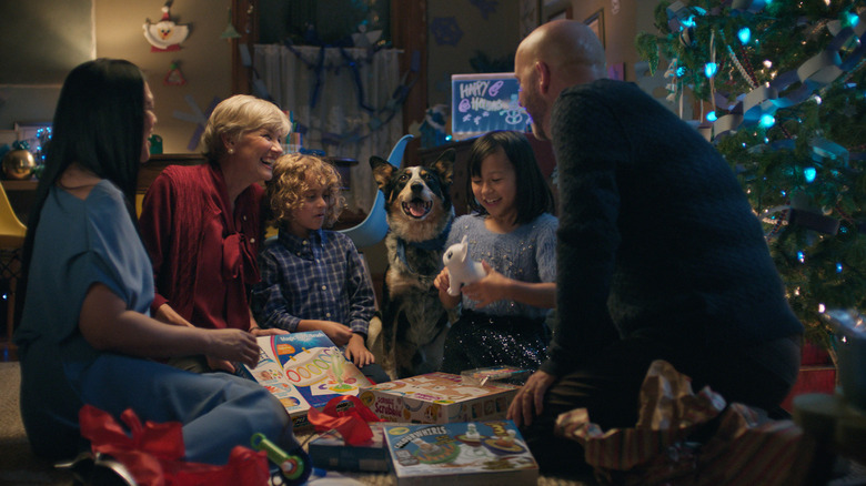 Family opening Christmas gifts, blue heeler seated with them