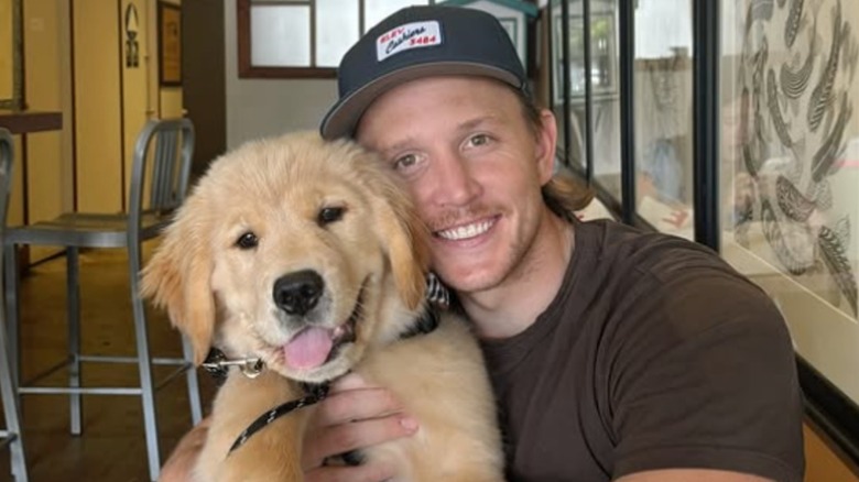Golden retriever and his male owner, seated in a restaurant