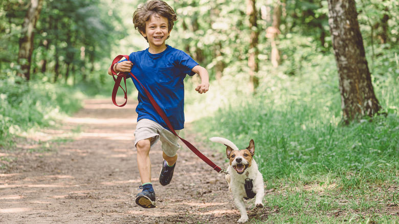A happy kid and dog going for a run.