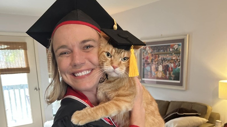 Woman and ginger cat graduate from college.