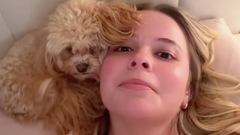 A TikTok influencer's maltipoo uses her head as a pillow at night.