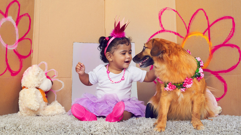 Little girl playing dress up with her dog