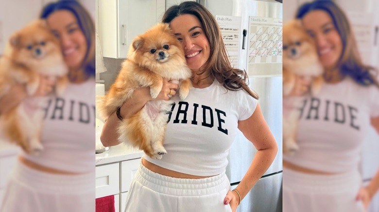 Chai the pomeranian being held by her mom in a kitchen.