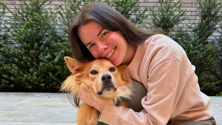 Isobel Klee snuggles Simon outside in front of shrubbery.
