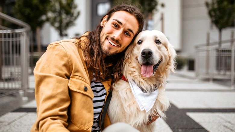 A man with his golden retriever outdoors