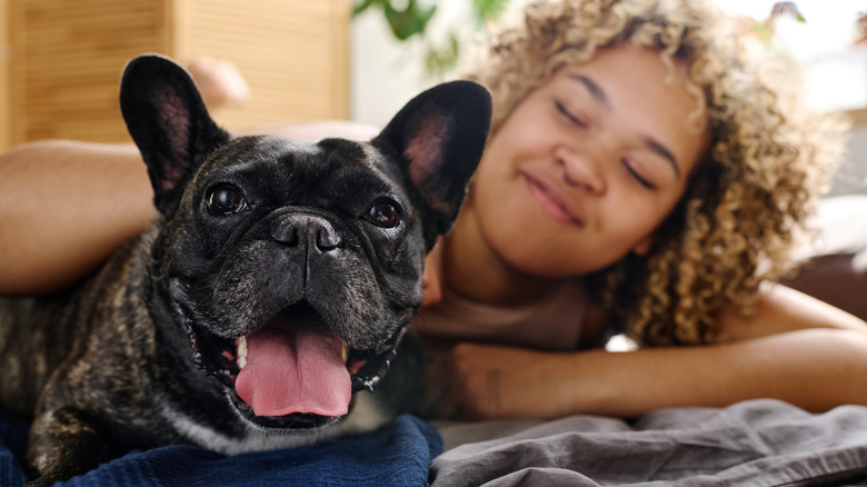 Happy dog with woman smiling in background