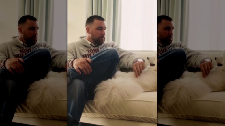 Travis Kelce on a couch with his Samoyed dog