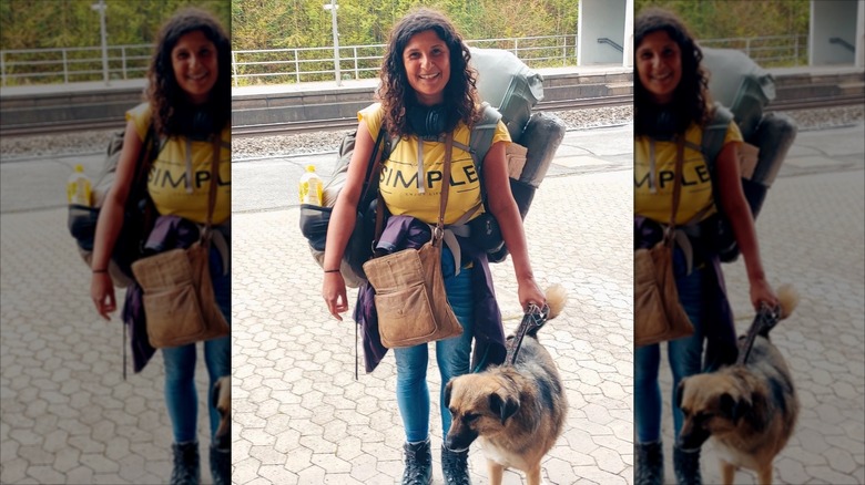 Woman with hiking gear and her dog on a leash