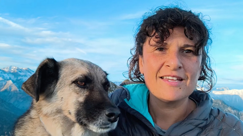 Woman and her dog against a mountain backdrop