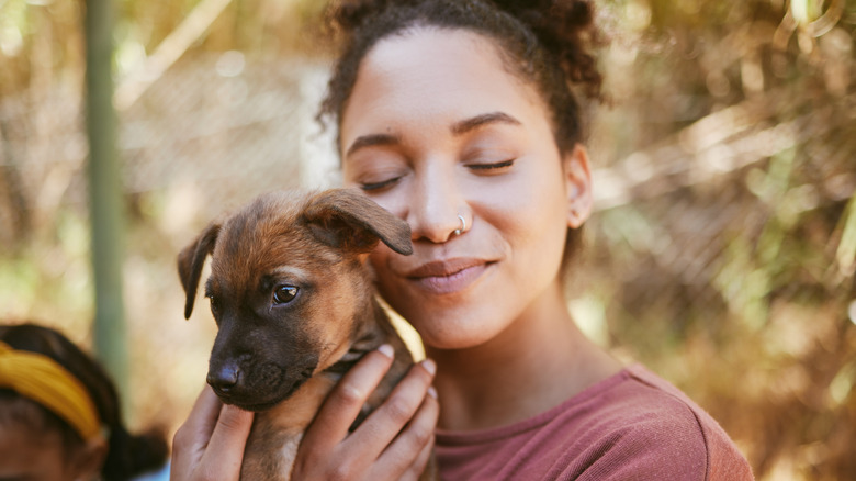 Person hugging a young pup.