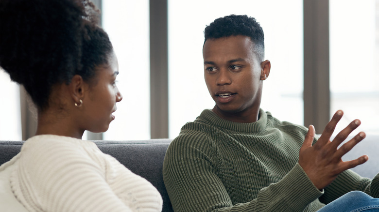 Man and woman sitting on sofa, having a serious talk