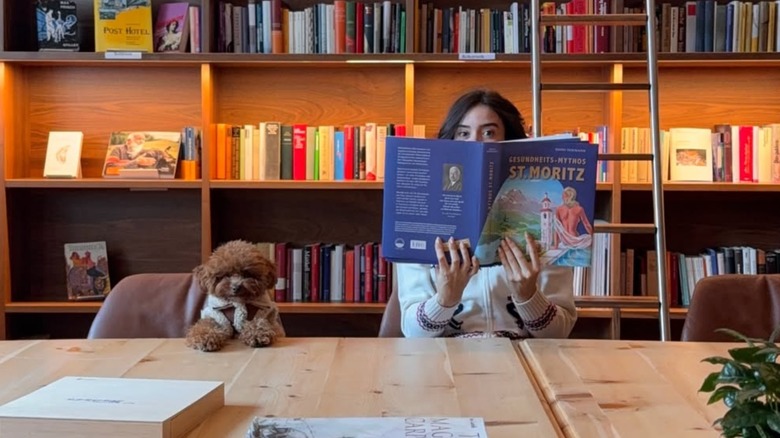 Toy poodle sits with his mom in a cute photo